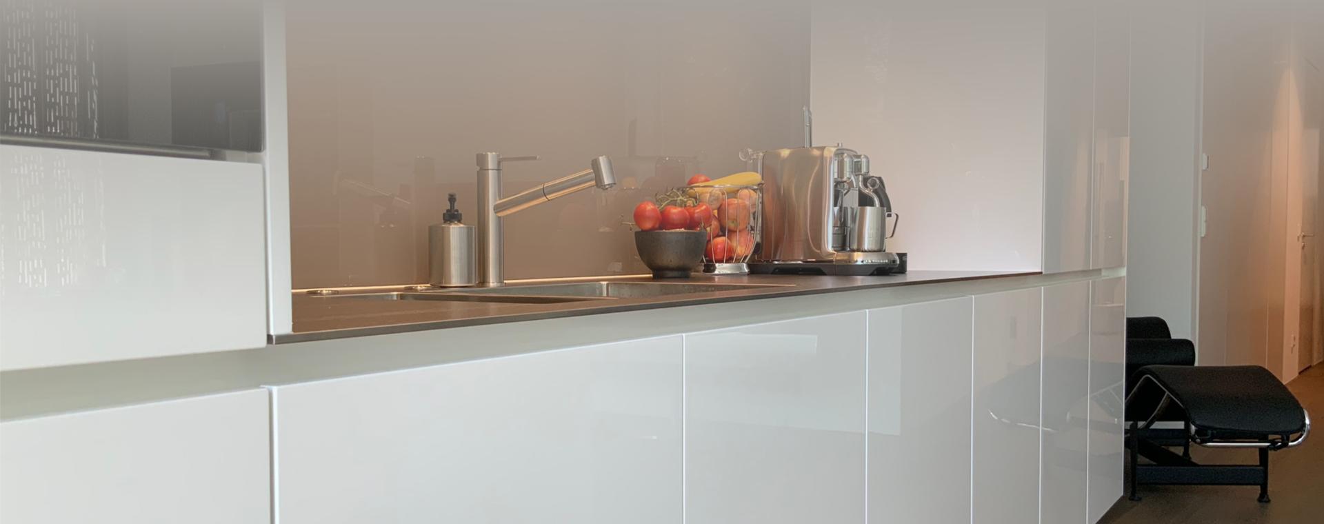 Küche in Hochglanz Weiß mit Arbeitsplatten in 8mm Pure-Steel-Edelstahl und Küchengeräten von Bora und Miele